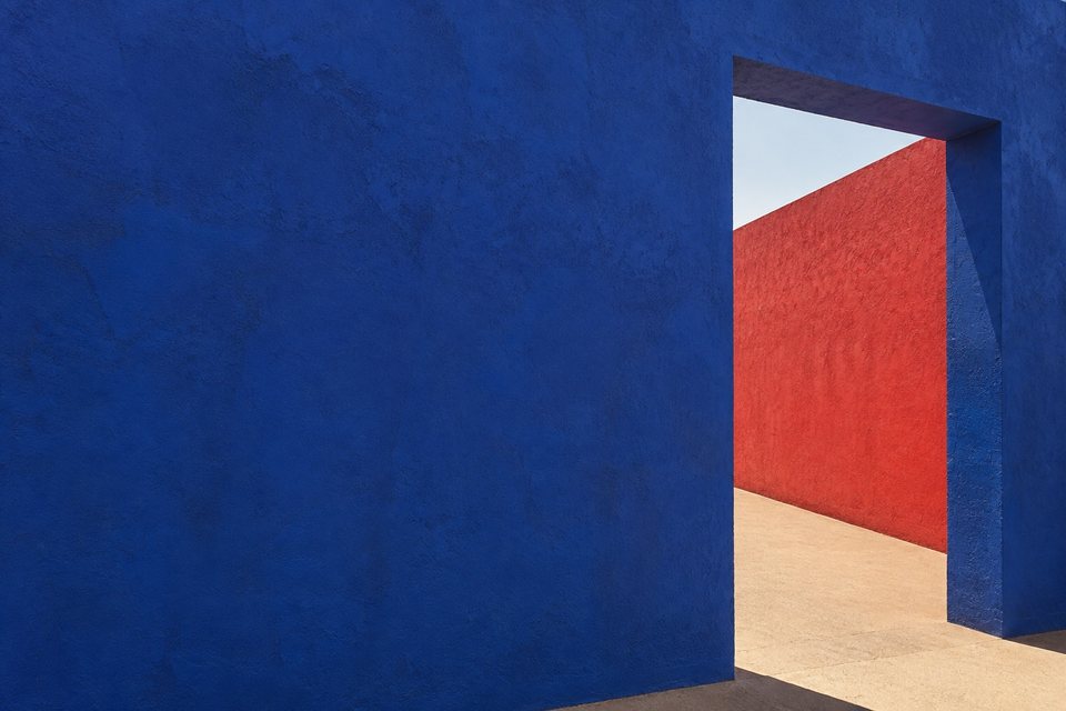 A cobalt blue opening leads into a sunlit space